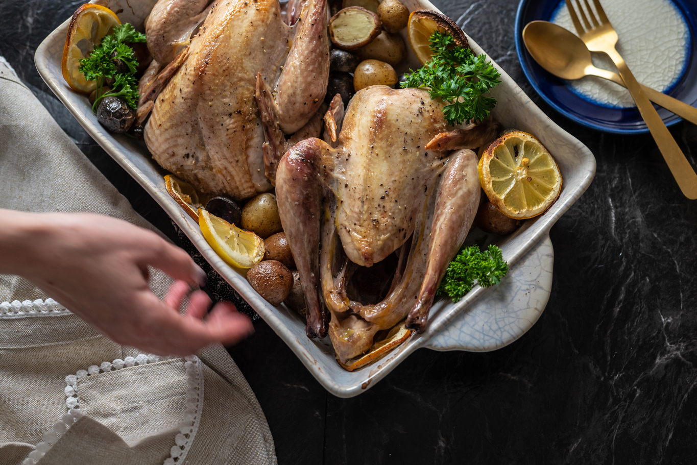 Two roasted pheasants in a serving tray.